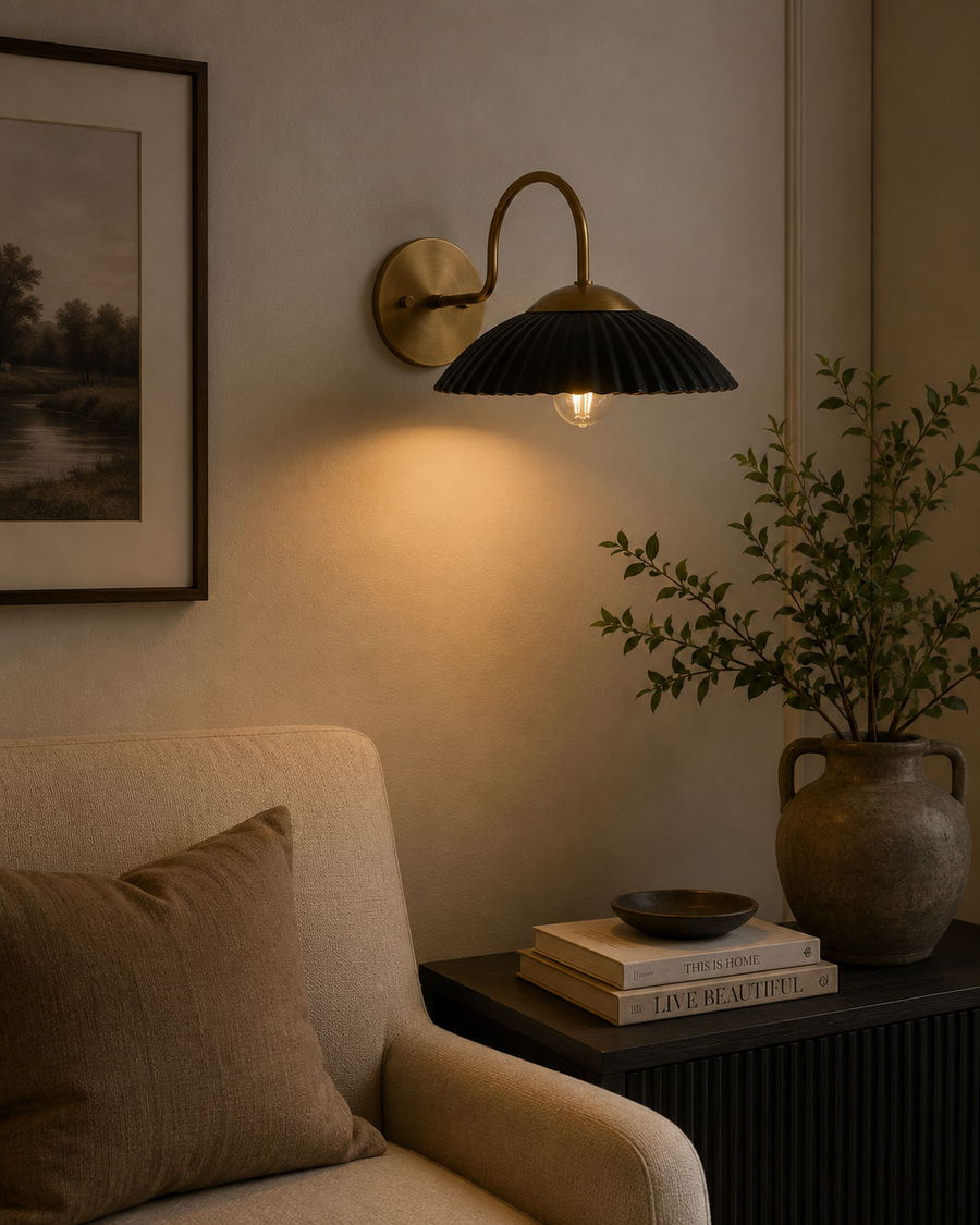 Cambria black fluted dome wall sconce with brass arm installed in a warm modern living room – Model 32785