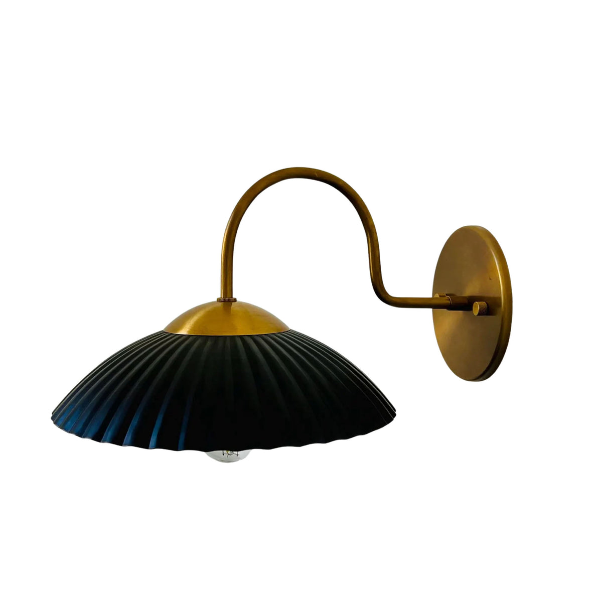 Reverse angled view of Cambria ribbed dome wall sconce with black shade and aged brass hardware – Model 32785