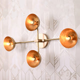 Capri Disc Linear Wall Light mounted on a bright patterned wall with four exposed bulbs and round shades.