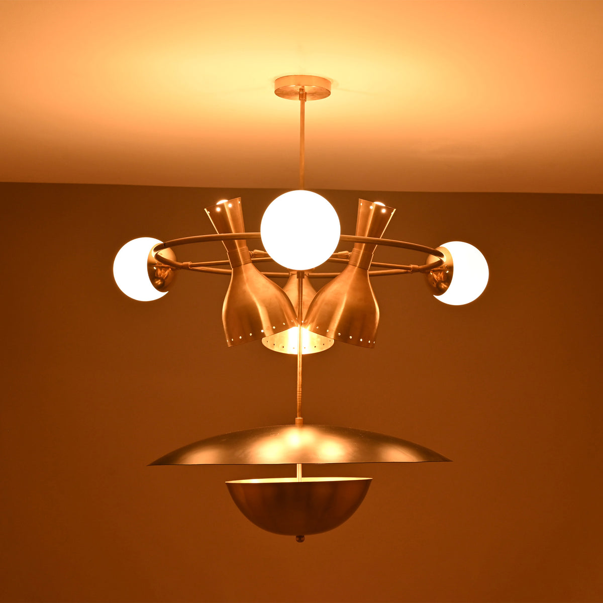 Capri Globe Disc Chandelier installed on ceiling with warm light effect, globe bulbs, and sculptural bottle shades.