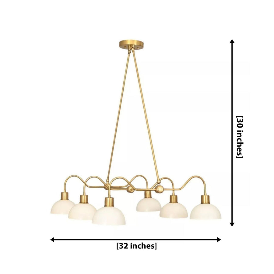 Casablanca 6 light brass-tone chandelier illuminated above a dining table with white dome shades in a warm modern interior.