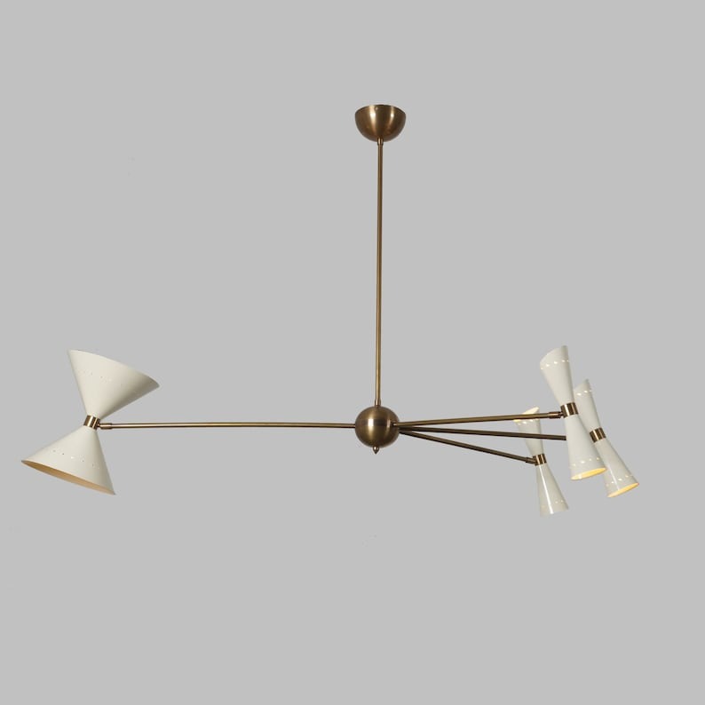Front view of the Catania 8-light sculptural chandelier featuring ivory double-cone shades, elongated brass-tone arms, a rounded central hub, and an elegant asymmetric silhouette.