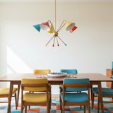 Catania 5 light Mid-Century Modern chandelier with colorful cone shades and brass-tone sculptural arms shown from an angled view.