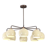 Eight-light chandelier with cream-colored globe shades and a brushed brass frame, ideal for modern and mid-century interiors