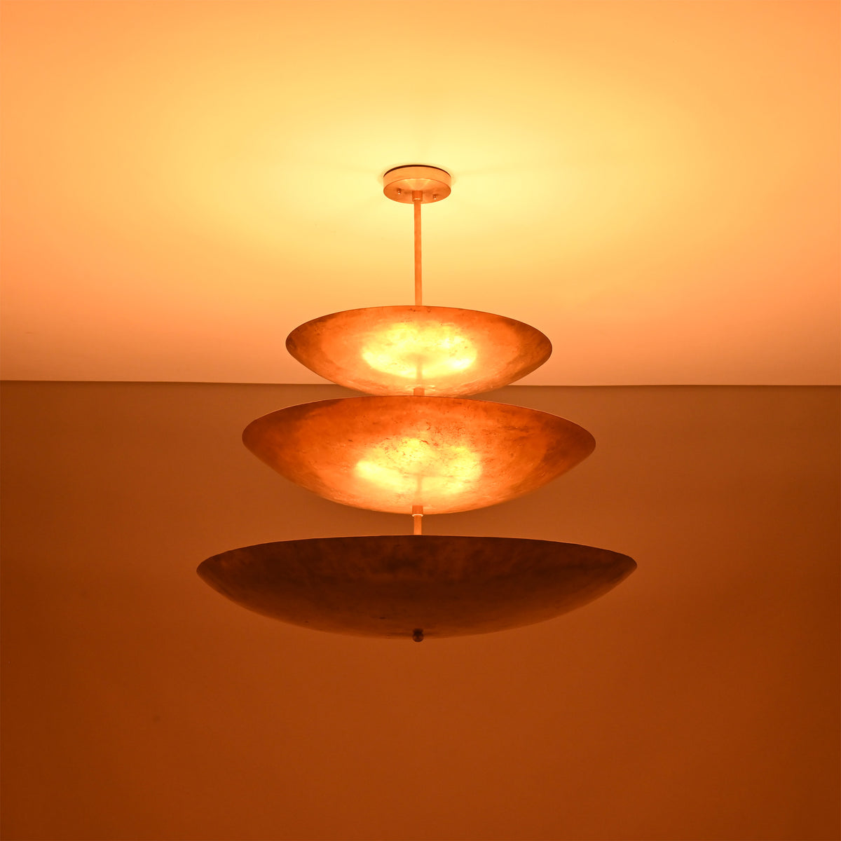 Close up of Celeste Triple Saucer Pendant Light highlighting warm light diffused through layered saucer shades.