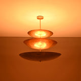 Close up of Celeste Triple Saucer Pendant Light highlighting warm light diffused through layered saucer shades.