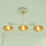 Bottom view of Charleston three-light chandelier showcasing wide conical shades, reflective gold interiors, and illuminated bulbs.