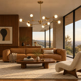 Chelsea 6 light sculptural chandelier featuring slender brass-tone arms, geometric joints and round globe bulbs.