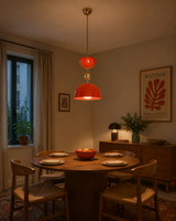 Cologne 1 light orange-red sculptural dome pendant displayed above a round wood dining table in a warm Mid-Century Modern dining room.