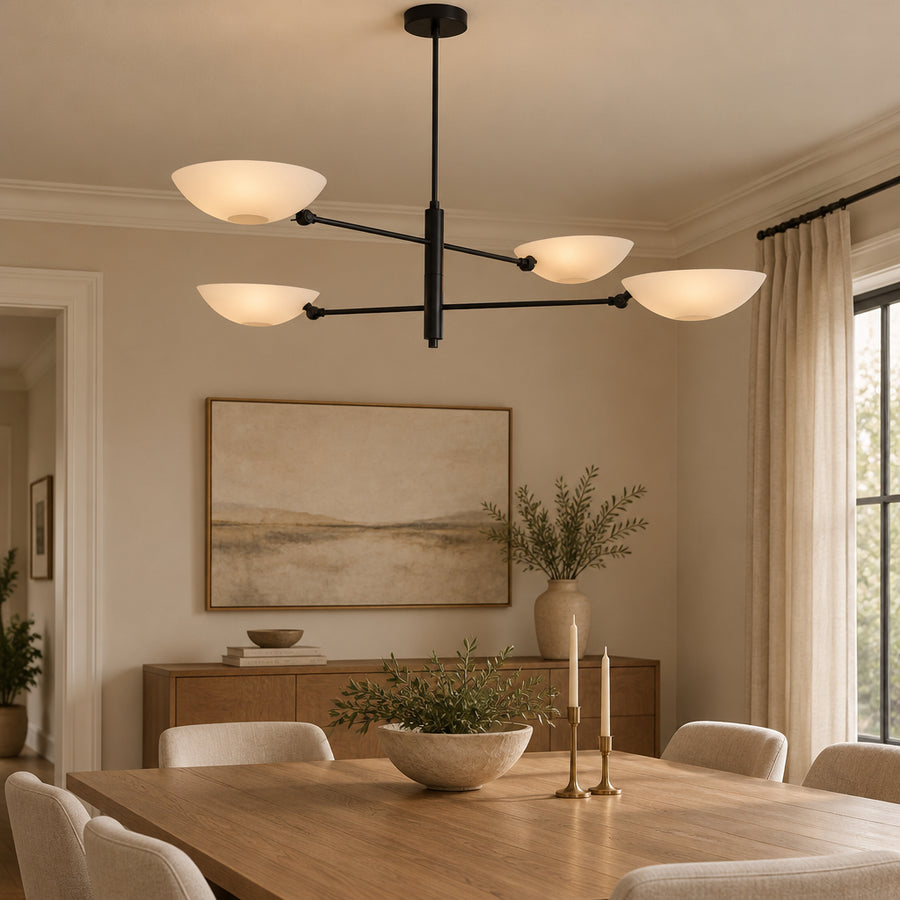 Front view of Como 4 light chandelier showcasing asymmetrically arranged white bowl shades, slender black arms, and a minimalist architectural silhouette.