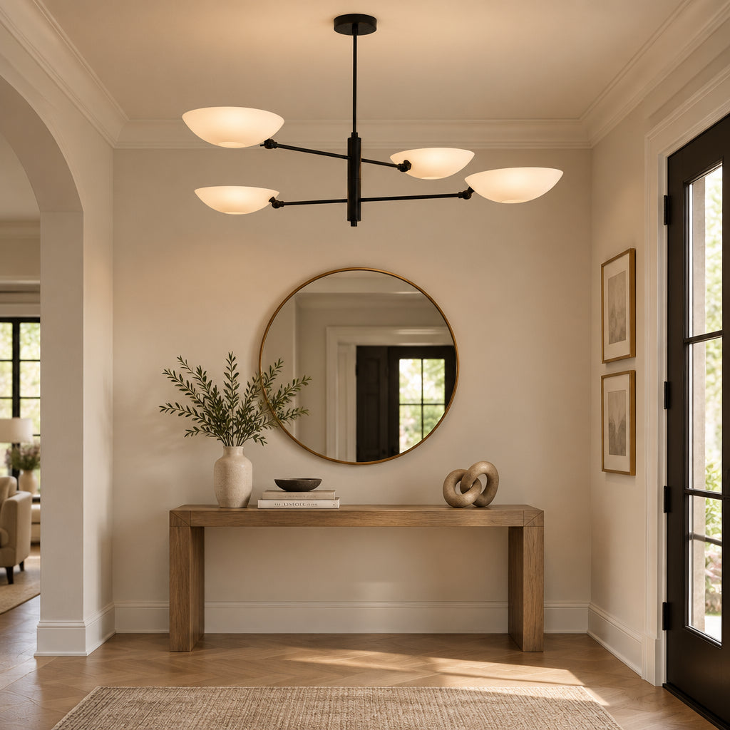 Full product view of Como 4 light sculptural chandelier featuring four curved white bowl shades, a black metal frame, and a round ceiling canopy.