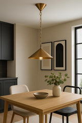 Brass cone pendant chandelier hanging over a wood dining table in a modern kitchen-dining space.