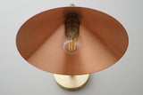 Close-up underside of brass cone shade showing warm copper-toned interior and exposed filament-style bulb, E26 wall sconce detail.