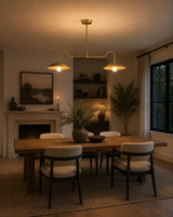 Cordoba 2 light brass linear dome chandelier installed above a wooden dining table in a warm modern dining room.