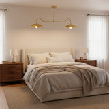 Cordoba 2 light linear brass chandelier shown from a straight front view with symmetrical dome shades and exposed bulbs.