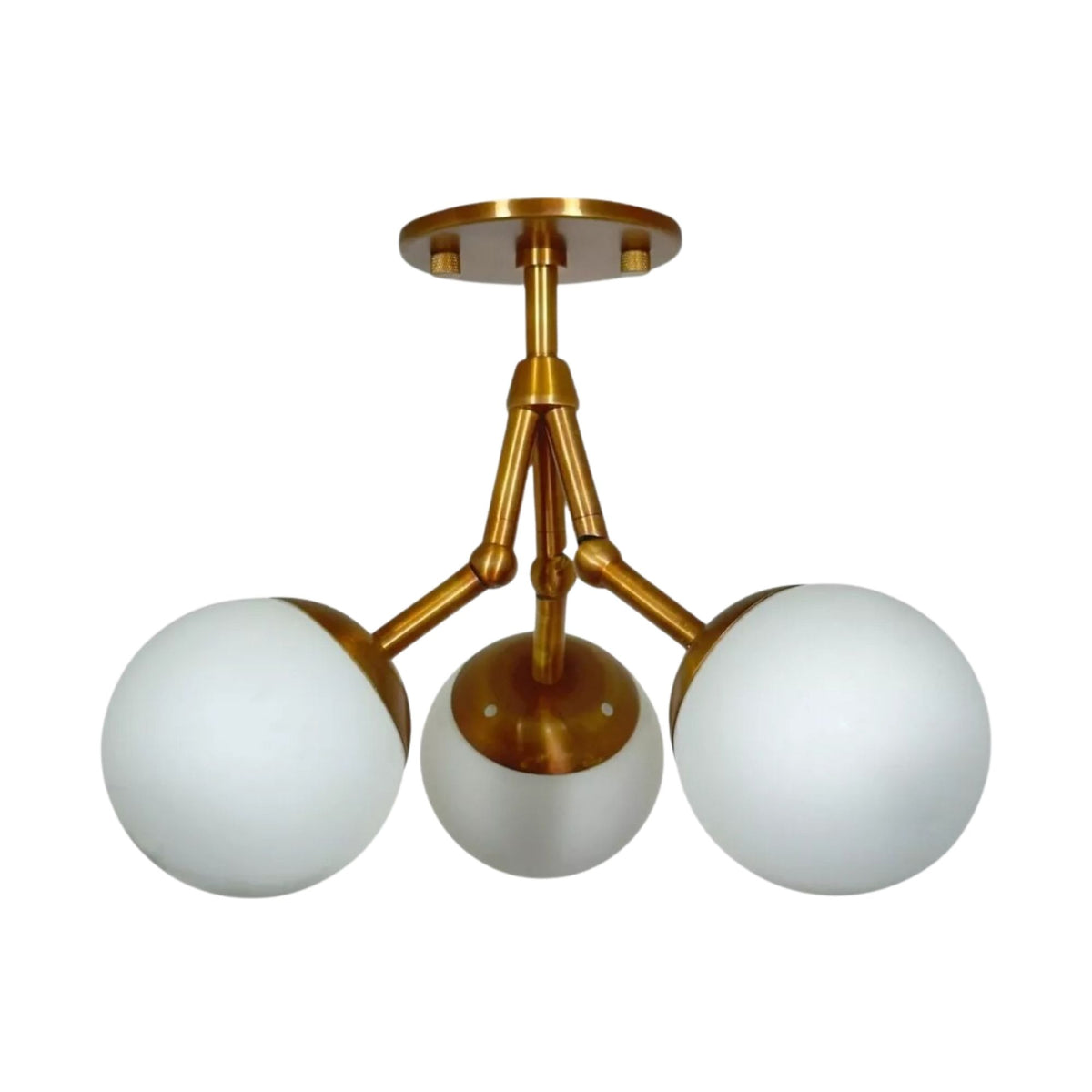 Cordoba 3 light Mid-Century Modern chandelier shown from the front with white opal globe shades, sculptural arms, and warm brass-tone finish.