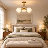 Cordoba 3 light Mid-Century Modern globe chandelier with opal glass shades displayed above a warm neutral bedroom.