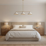 Corfu 3 light linear chandelier featuring three white cone shades suspended from a minimalist brass frame.