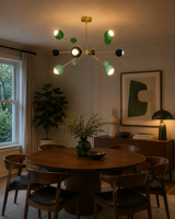 Crete 12 light multicolor Sputnik chandelier illuminated above a round wooden dining table in a warm contemporary dining room.