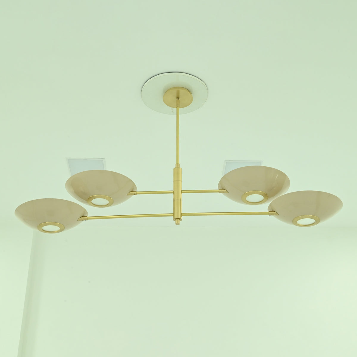  Dallas 4-light sculptural linear chandelier featuring four shallow bowl shades, a brass-finished frame, and modern ceiling-mounted design.