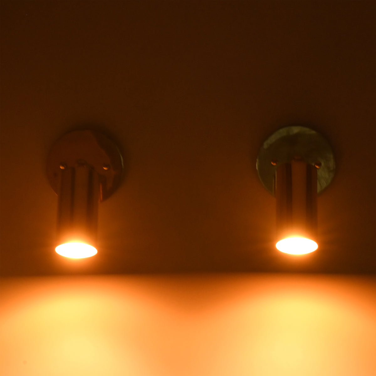 Adjustable brass cylinder wall light providing warm focused downward illumination for bedside, hallway, and reading applications.