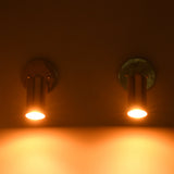 Adjustable brass cylinder wall light providing warm focused downward illumination for bedside, hallway, and reading applications.