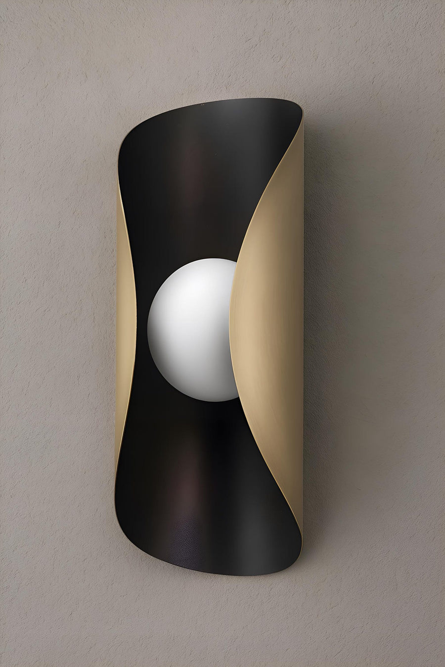 Curved brass wall sconce with blackened exterior and brushed brass interior featuring a central frosted globe for soft ambient lighting