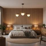 Wide front view of Eclipse 3 light chandelier with warm brass disc shades, opal globes and dark metal frame