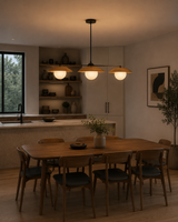 Eclipse 3 light disc globe chandelier illuminated above a wooden dining table in a modern warm-toned dining room