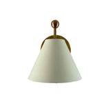 Front angled view of the Elara modern ivory tapered wall sconce featuring a handcrafted conical metal shade, decorative brass finial, and round brass wall backplate.