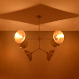 Florence Disc Orbital Chandelier installed on ceiling with four rounded shades and dramatic warm shadow pattern.