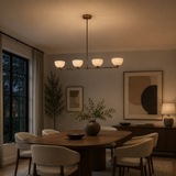 Florence 4 light cream bowl chandelier illuminated above a dining table in a warm contemporary dining room.