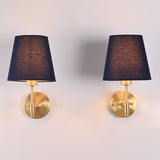 Front view of a handcrafted antique brass wall sconce featuring a blue tapered fabric shade, round brass backplate, and elegant modern classic design.