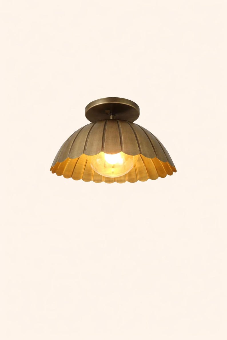 Brass scalloped dome flush mount ceiling light in brushed brass with warm glowing bulb, 12-inch flower bowl shade.