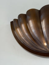 Close-up detail of fluted scallop brass wall sconce showing curved petals and outer rim in warm bronze/aged brass finish.