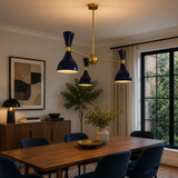 Hamburg 6 light navy blue and brass double-cone chandelier illuminated above a modern wooden dining table.