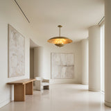 Hamptons 3 light brass-tone dome chandelier shown illuminated with warm ambient light reflecting beneath the sculptural shade.