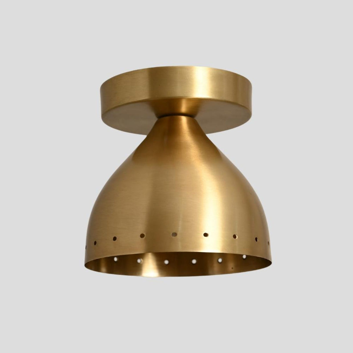 Industrial-style brass ceiling light with conical perforated dome, handcrafted for durability and timeless elegance.