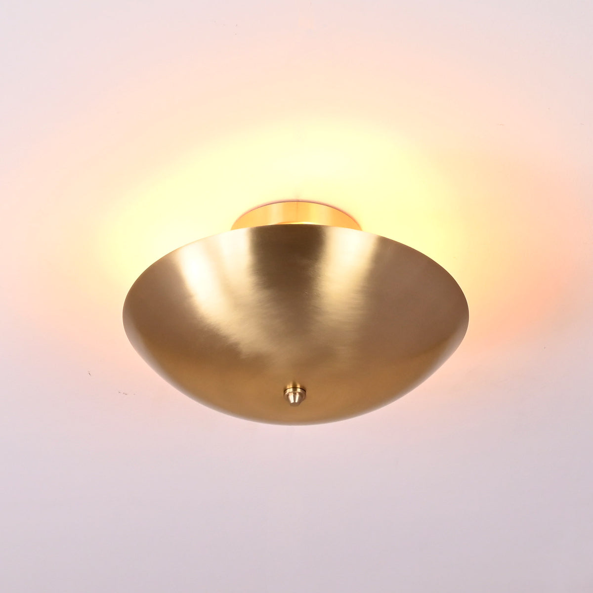 Close-up view of handcrafted brushed brass ceiling light highlighting smooth curved bowl design