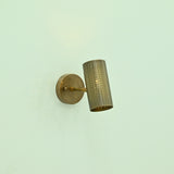 Hobart antique brass wall sconce featuring an angled perforated cylindrical shade, slim support arm, and round metal wall mount.
