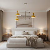 Hong Kong 6 light sculptural chandelier shown from the side with yellow dome shades, streamlined metal arms, and counterbalance sphere accents.