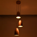 Close-up of the Hudson Cascading Cone Cluster Pendant Light displaying warm downward light and handcrafted copper textures on each cone shade.
