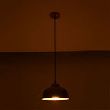 Hudson copper dome pendant light creating a warm ambient lighting effect in a dark interior.