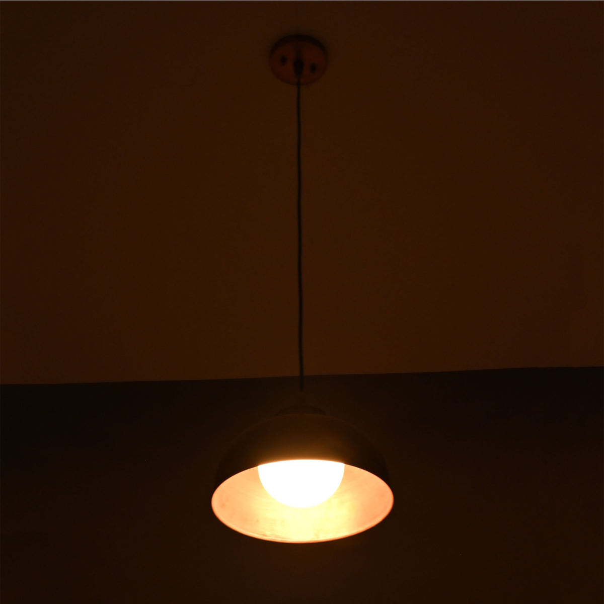 Hudson copper dome pendant light displaying warm downward illumination through the wide copper shade.