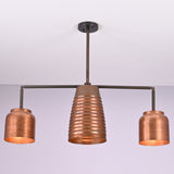 Angled view of the Hudson Modern Linear Copper Chandelier highlighting the ribbed center shade and balanced three-light design.