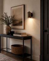 Hudson Dome Wall Sconce installed in a modern hallway, providing warm downward accent lighting above a console table in a contemporary minimalist interior.