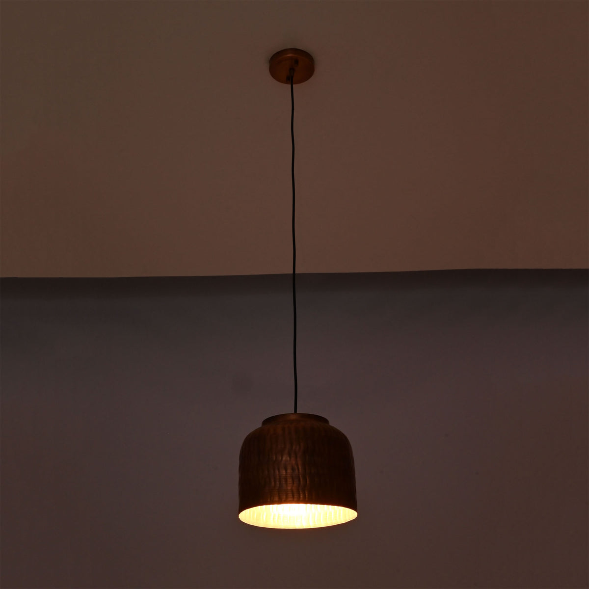 Hudson hammered dome pendant light with warm glowing interior highlighting handcrafted copper texture