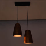 Warm illuminated Hudson Modern Artisan pendant light with handcrafted copper cone shades creating soft downward lighting.