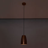 Hudson brushed copper bell pendant light illuminated with warm downward lighting in a dark setting
