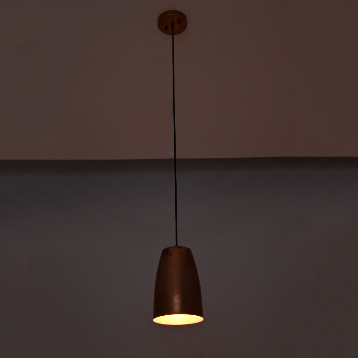 Hudson modern copper bell pendant lamp casting warm ambient light with adjustable ceiling suspension